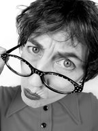 Person wearing large black glasses with a white background