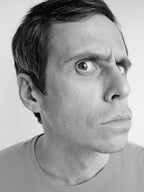 Black and white portrait of a person wearing a gray shirt.