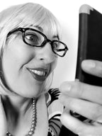 Person with glasses and a striped shirt holding a phone